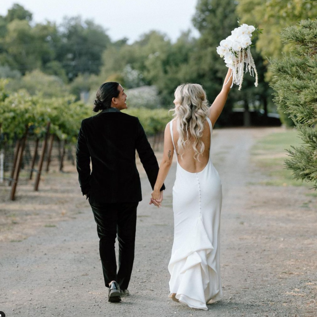 Bride and groom walking a Napa Valley vineyard lane on their elopement day